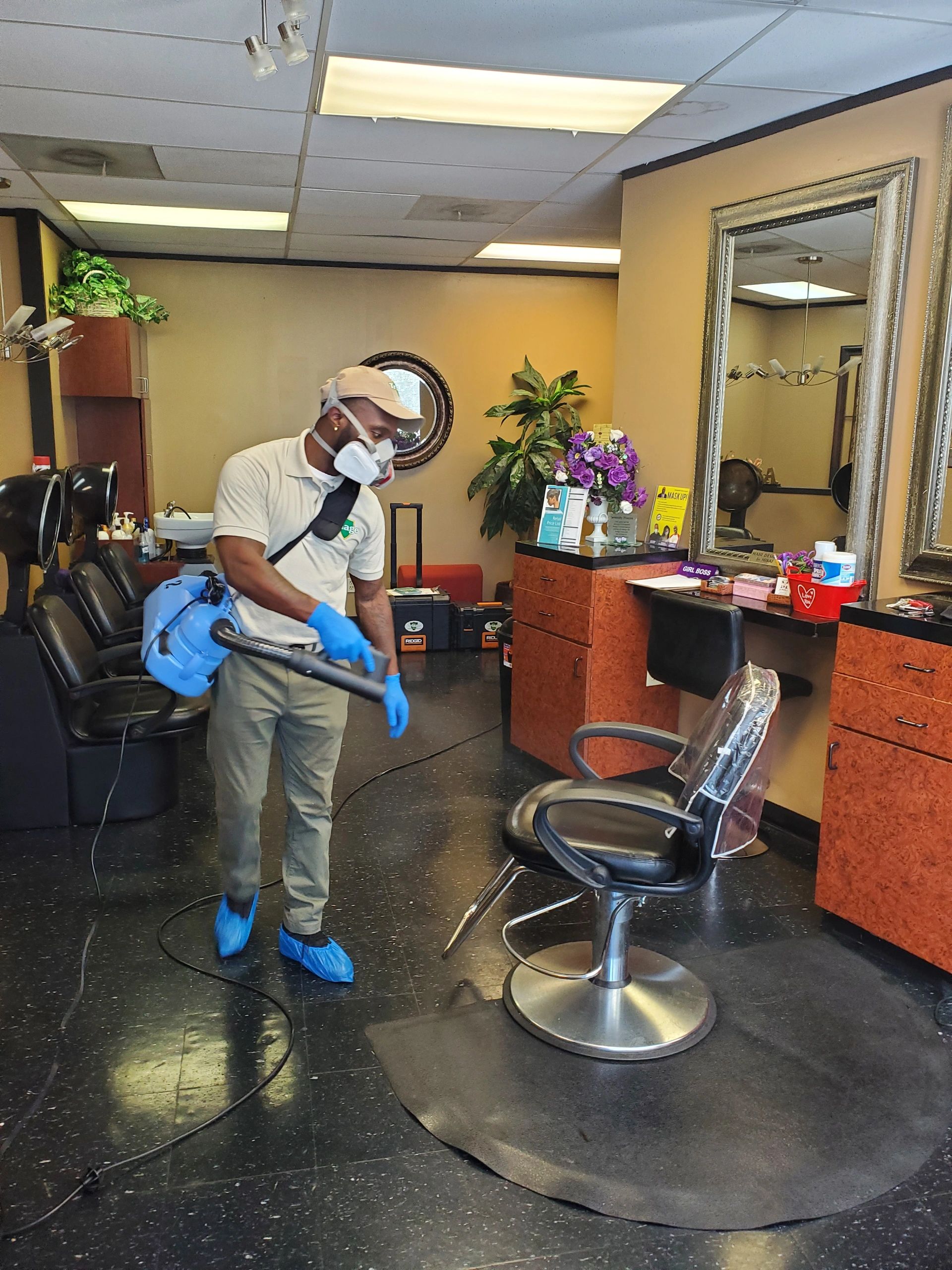 A uniformed cleaner working around a barbershop chair